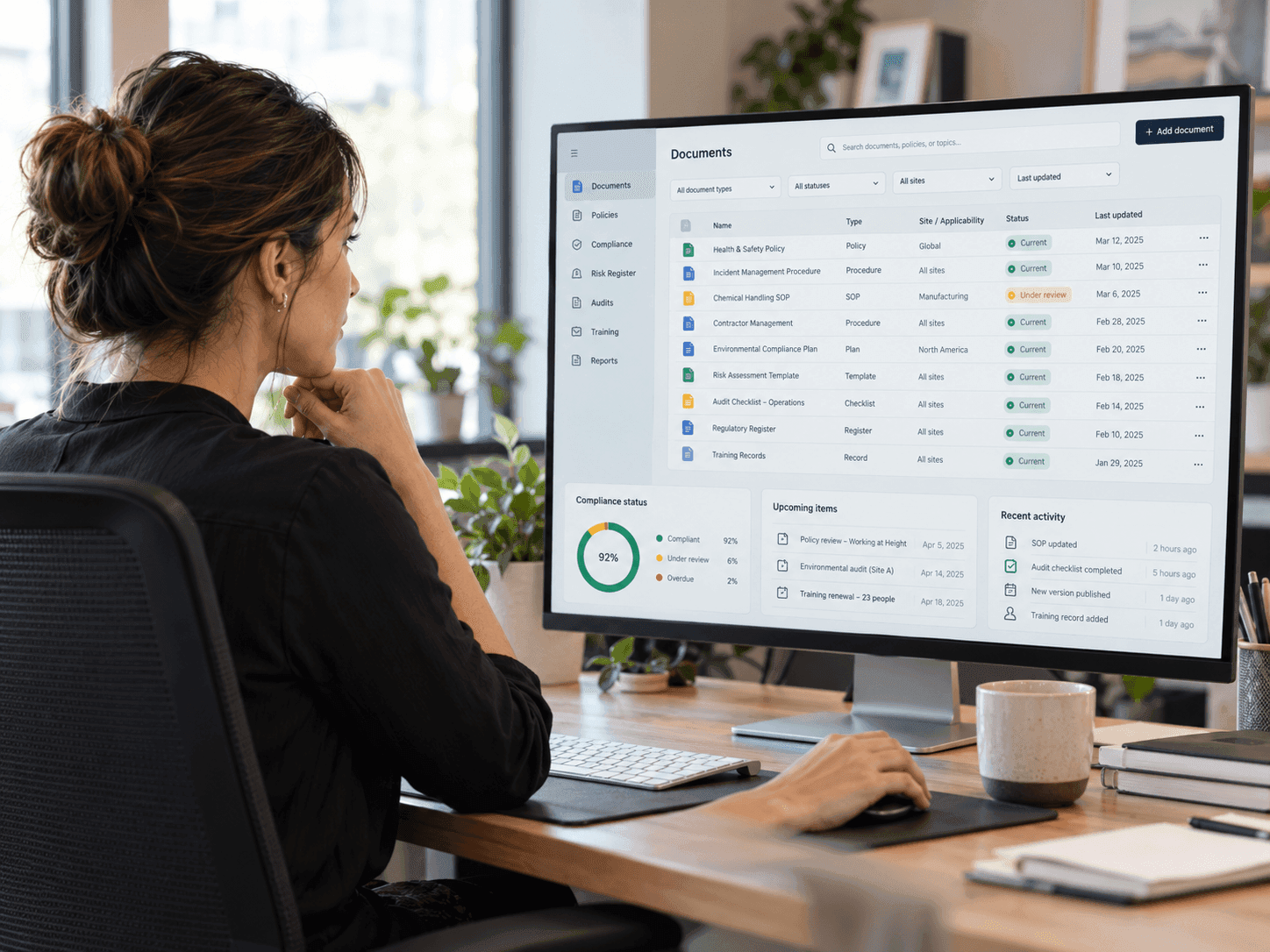 Illustrative image for De-risk & Comply: Real photo of a compliance manager reviewing organized digital records, calm and in control.