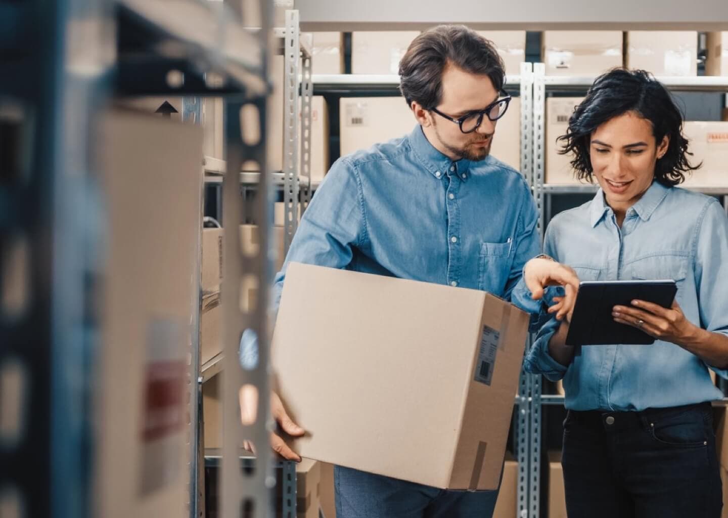 Real photo of a confident operations director in a growing company's distribution center reviewing metrics on a tablet, professional and in control.